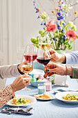 People toasting each other with wine at a laid Easter table