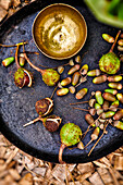 Horse chestnuts and acorns with brass bowl on a rustic tray