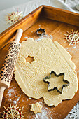 Butter biscuit dough with Christmas motif and snowflake-shaped cookie cutter