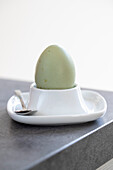 Green hen's egg in an egg cup