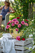 Blumenstrauß mit Dahlien und Astern, Frau im Hintergrund