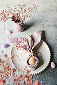 Easter decoration with egg, cloth napkin and spring flowers