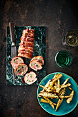 Roll roast wrapped in bacon with roasted parsnips