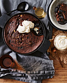 Baked chocolate pudding with chocolate sauce and cream