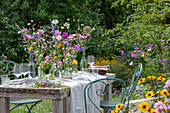 Gedeckter Tisch mit Blumenschmuck, Ringelblume (Calendula), Kosmee (Cosmos), Flammenblume (Phlox), Skabiose, Kugellauch (Allium) in Vasen