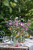Gedeckter Tisch mit Blumenschmuck, Ringelblume (Calendula), Kosmee (Cosmos), Flammenblume (Phlox), Skabiose, Kugellauch (Allium) in Vasen
