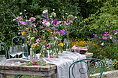 Gedeckter Tisch mit Blumenschmuck, Ringelblume (Calendula), Kosmee (Cosmos), Flammenblume (Phlox), Skabiose, Kugellauch (Allium) in Vasen