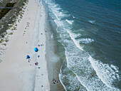 Aerial view of a beautiful sandy beach with people enjoying the waves and dunes,Tybee Island,United States