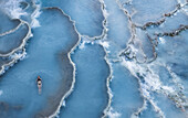 Aerial view of woman enjoying sunrise at Terme di Saturnia thermal springs,Tuscany,Italy