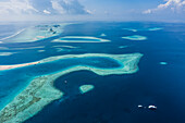 Luftaufnahme eines wunderschönen Atolls mit Barriereriff, umgeben vom Indischen Ozean, Malediven