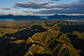 Aerial view of jinshanling great wall amidst majestic mountains and serene valley at sunset,chengde,china
