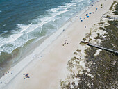 Luftaufnahme eines sonnigen Strandes mit Wellen und Menschen in der Nähe von Sanddünen, Tybee Island, Vereinigte Staaten