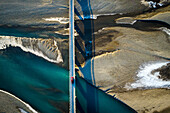 Aerial view of glacial patterns and river with bridge and red car in Stafafell,Eastern Iceland