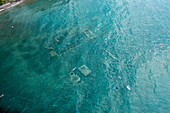 Aerial view of underwater ruins in clear blue sea with swimmers,Archea Epidavros,Greece