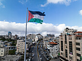 Aerial view of bustling cityscape with vibrant buildings and Palestinian flag,Hebron,Palestine