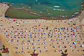 Aerial view of a beautiful sandy beach with people sunbathing under colorful umbrellas,Black Sea,Sariyer,Turkey