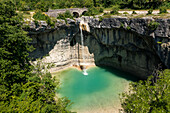 Luftaufnahme eines atemberaubenden Wasserfalls in einer üppig grünen Schlucht, umgeben von schroffen Felsen und einem ruhigen Wald, Pican, Kroatien