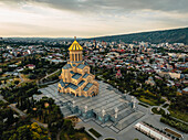 Aerial view of holy trinity cathedral amidst urban landscape with mountains in the background,Avlabari,Georgia