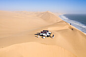 Aerial view of people doing a photo shooting on the sand dunes along the coastline near Walvis Bay,Namibia