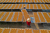 Hung Yen,Vietnam - 15 December 2019: Aerial view of two people working in a farm with round incense,preparing the incense on similar trays,Hung Yen,Vietnam