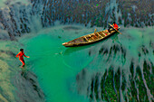 Badalgachhi,Bangladesh - 30 January 2021: Aerial view of fishermen on a canoe sailing the Jamuna river,Bangladesh