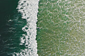 Aerial view of a surfer swimming in the ocean waves in Peniche,Portugal