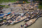 Dhaka,Bangladesh - 04 August 2021: Aerial view of people trading and sailing using long fishing canoes along Kaliganga river,Ghior,Dhaka province,Bangladesh