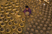 Sahajanpur,Bangladesh - 27 January 2020: Aerial view of a kid sitting among clay pots in a small factory in Rajshahi state,Bangladesh