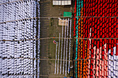 Luftaufnahme von Arbeitern, die Tausende von Metern verschiedenfarbiger T-Shirt-Stoffe zum Trocknen aufhängen, in Narayanganj, Dhaka, Bangladesch