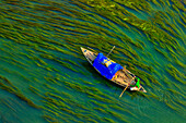 Aerial view of a person sailing with a canoe in the river with Algae,Sirajganj,Bangladesh