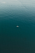 Aerial view of a person canoeing into the sea in Cefalù,Sicily,Italy