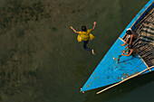 Dhaka,Bangladesh - 23 January 2017: Aerial view of kids playing in the water jumping from a fishing boat,Bangladesh