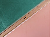 Aerial view of the pink Lake McDonnell with a car driving on the road that divides the pink salt from the blue water,Eyre Peninsula,Australia. Top down perspective