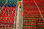 Dhaka, Bangladesch - 18. Mai 2021: Luftaufnahme von Arbeitern, die bunte T-Shirt-Stoffe zum Trocknen in Narayanganj, Dhaka, Bangladesch, aufhängen