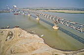 Aerial view of a building site while assembling the Padma bridge,the longest rail and highway bridge in Bangladesh crossing the Padma river,Zajira,Dhaka,Bangladesh