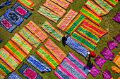Luftaufnahme von Menschen, die in einer öffentlichen Wäscherei arbeiten und bunte Kleidung bei Sonnenlicht trocknen, Araihazar, Provinz Dhaka, Bangladesch