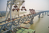 Aerial view of a building site while assembling the Padma bridge,the longest rail and highway bridge in Bangladesh crossing the Padma river,Zajira,Dhaka,Bangladesh