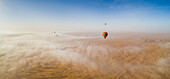 Aerial view of hot-air-balloon flying in the clouds of the Murqquab desert in Dubai,U.A.E