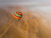 Aerial view of hot-air-balloon flying in the clouds of the Murqquab desert in Dubai,U.A.E