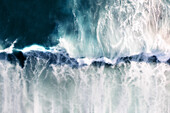 Aerial view of a blue ocean wave breaking,with white foam and a motion blue effect,Cape Town,Western Cape,South Africa