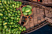 Dhaka,Bangladesh - 27 March 2022: Aerial view of workers unloading watermelons on typical boats along the Buriganga River