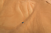 Aerial view of a single car driving on the middle of desert,U.A.E