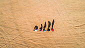 Aerial view of friends imitating the human evolution with their shadows in the Sharjah desert,U.A.E