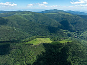Luftaufnahme von üppig grünen Bergen und ruhigen Wäldern über einem malerischen Tal, Kruth, Frankreich