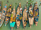 Aerial view of people trading with fruits and vegetables on boats along the river in Dhaka,Bangladesh
