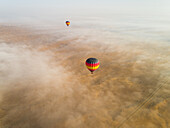 Aerial view of a group of hot-air-balloon flying in the clouds of the Murqquab desert in Dubai,U.A.E