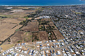 Luftaufnahme von Häusern an der Küste und Ackerland in der Nähe des Ozeans, Ocean Grove, Australien