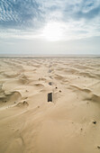 Abstrakte Luftaufnahme einer mit Sand bedeckten Straße in der Wüste, Abu Dhabi, Vereinigte Arabische Emirate