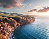 Luftaufnahme der Küstenlinie der Fleurieu Peninsula Sellicks Beach von hoch über dem Strand mit sanften Sonnenuntergangswolken im Hintergrund, Fleurieu Peninsula, South Australia, Australien