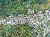 Luftaufnahme einer malerischen Kleinstadt mit schönen Gebäuden und einem ruhigen Fluss, umgeben von üppigem Grün und Wald, Thann, Frankreich